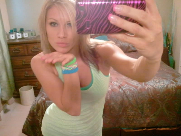 A slender blonde spreads her pussy lips with her fingers