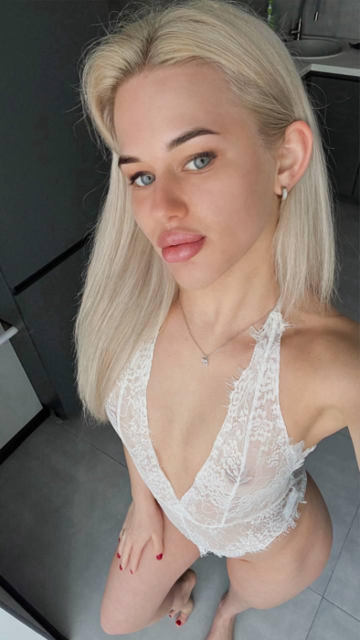 Young woman in school uniform sitting at a back classroom desk